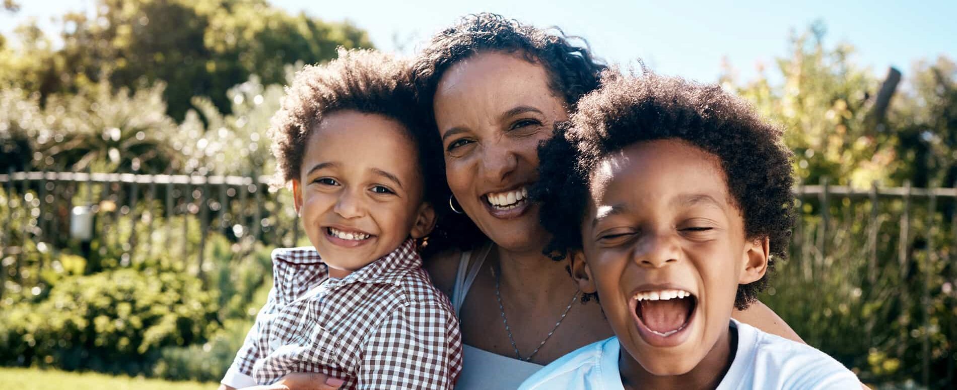 A mother and her two children outside in nature.